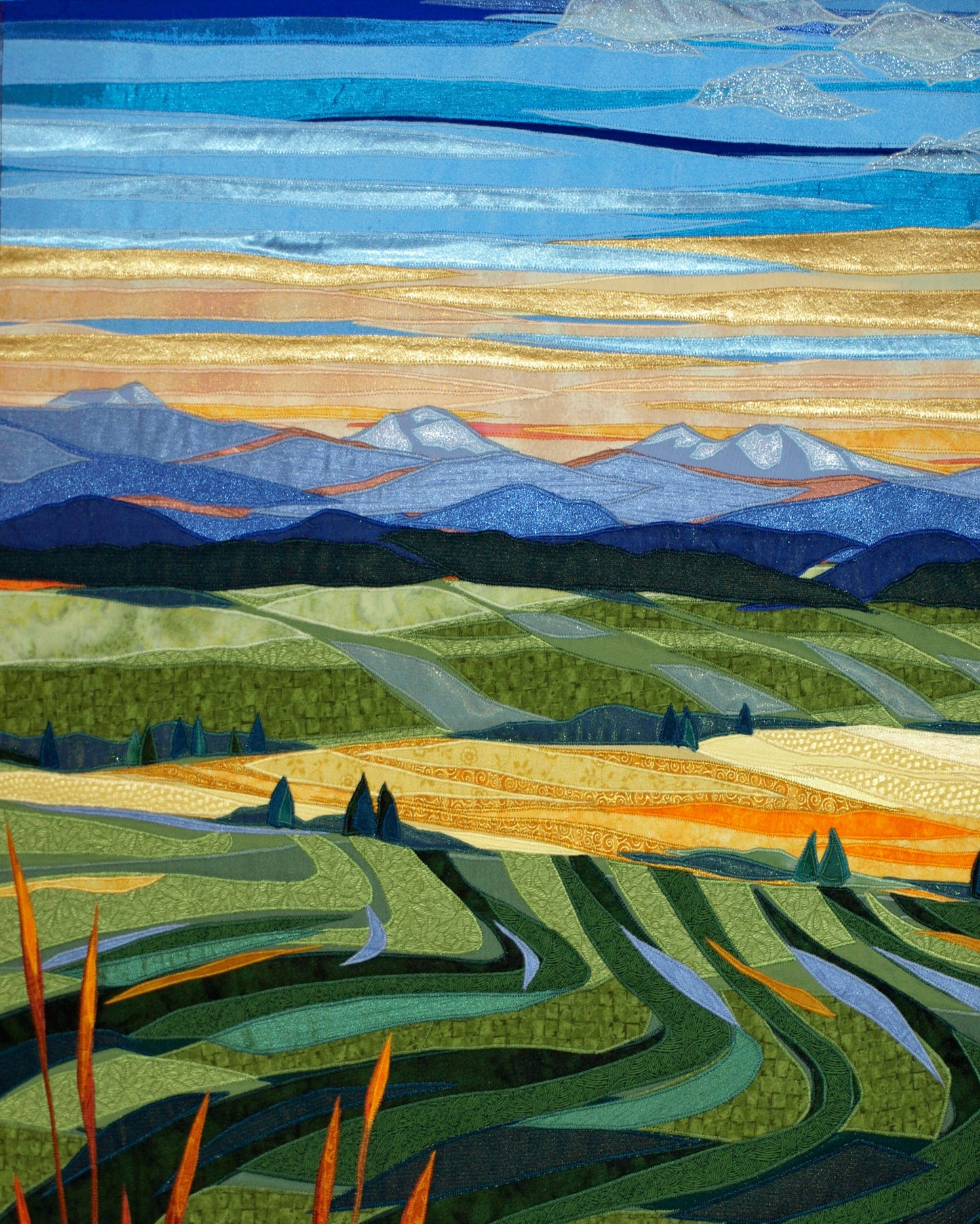 A reproduction of a landscape with rolling hills and mountains. The original was created with stitched fabrics.